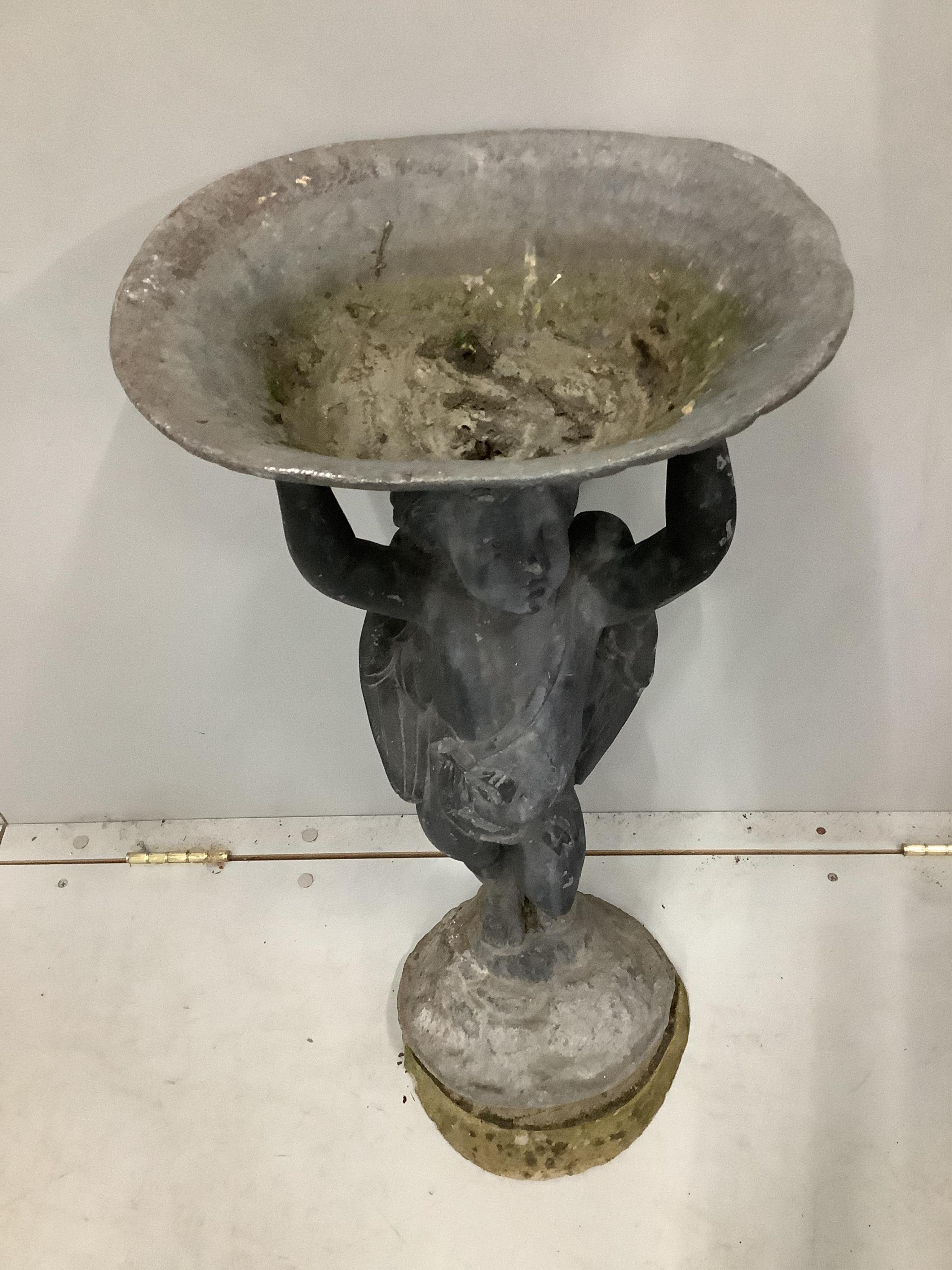 A lead bird bath with cupid stem, height 73cm. Condition - weathered with some old dents and scratches, base is levelled with cement but overall fair to good